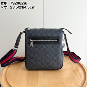 Batch 270... Style No.: 792082 Dimensions: 23.5/21/4.5cm Small Size New Black Vinyl Men's Bag Minimalist Design for Timeless Appeal Classic Red & Blue Woven Strap Adjustable Crossbody Length