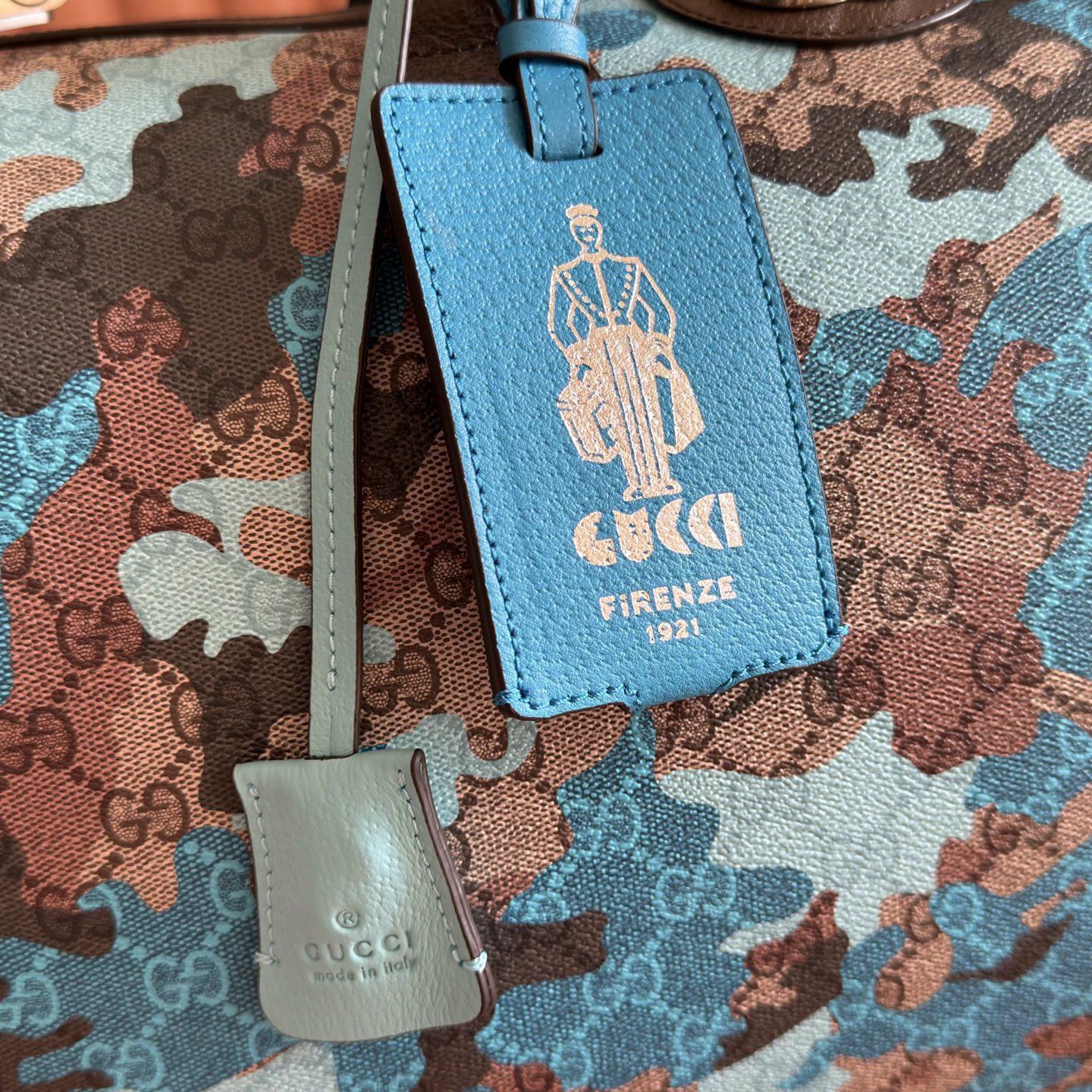 p970๐๐๐ Vibrant camouflage meets distinctive color combinations, reimagining the iconic GG pattern. Crafted from marble-effect GG monogram coated fabric, this travel bag features a matching ID tag and key ring.Pink and red camouflage marble GG monogram coated fabric Brown, pink, and red leather trim Palladium-tone hardware Natural cotton-linen lining Double G Capacity: 28 liters Interior: 1 zippered pocket Exterior: 1 removable luggage tag, 1 lock, 1 key ring Handle height:12 cm. Detachable adjustable leather shoulder strap (height: 119 cm - 134 cm). Zipper closure. Model: 834460. Dimensions: 44 cm (width) x 29 cm (height) x 25 cm (depth). Weight: approx. 2.3 kg. Color: Blue camouflage/PVC. Made in Italy. - Image 6