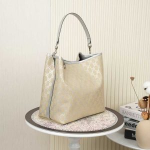 Alternative view of Batch 340... The all-new GG Emblem collection reinterprets the brand's timeless elegance and masterful craftsmanship. This compact shoulder bag embodies practical design aesthetics, featuring two main compartments and a central zippered pocket, with an accompanying leather shoulder strap for crossbody wear.Light beige and silver GG monogram coated fabric with silver leather piping and contrasting stitching. Interior: 2 main compartments and 1 central zippered pocket. Handle height: 18 cm. Leather shoulder strap (height 54–60 cm; length 105–115 cm). Weight: approx. 700 g. Model: 815103.Dimensions: 25 cm (W) x 25 cm (H) x 15.5 cm (D) Color: Apricot Silver/Genuine Leather Made in Italy