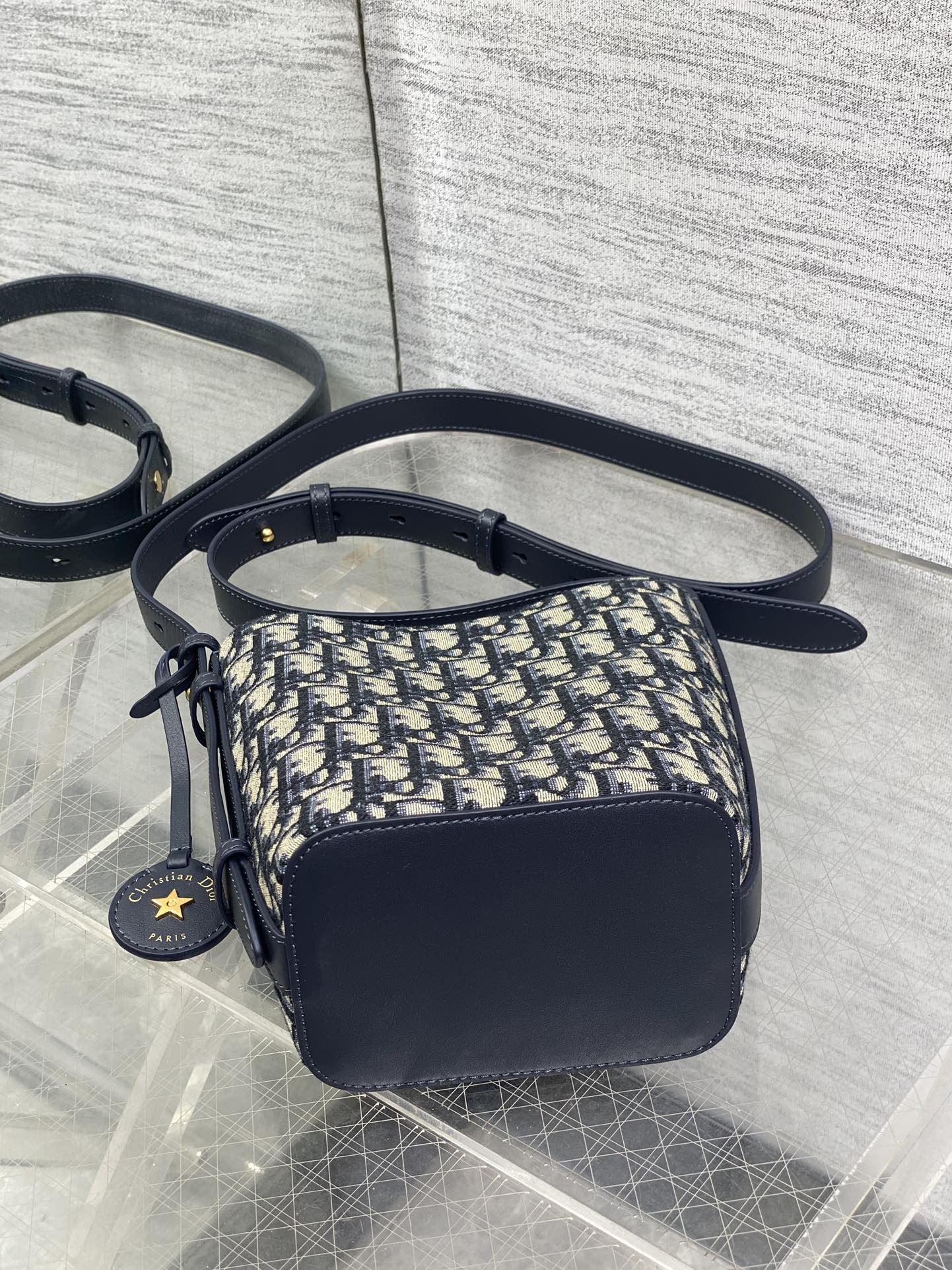In Stock‼️ Dior's New Star Bucket Bag Collection The latest stunning handbags have arrived! Crafted from classic Oblique monogram fabric with exquisite workmanship, this adorable bucket bag design blends elegance with modern style. Its soft silhouette features a drawstring closure and removable long shoulder strap, combining practicality with beauty. Perfect for holiday outings—carry it with flair wherever you go! - Image 6