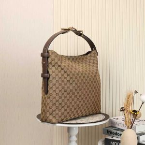 Alternative view of Batch 340...2025 Fall/Winter Collection. The Gucci Beatrix handbag is expertly crafted from black calf leather, featuring a shoulder strap adorned with the iconic horsebit detail that infuses casual silhouettes with the brand's essence. Gold-tone hardware adds refined sophistication, while an interior zippered pocket ensures daily essentials stay secure. Combining elegant design with practical functionality, it effortlessly accommodates everyday necessities.Black soft smooth calf leather Gold-tone hardware Black cotton-linen blend lining Shoulder strap with horsebit detail Interior: Zippered pocket Adjustable shoulder strap height: 26 cm - 33 cm; Length: 94 cm Model: 850546 Dimensions: 40 cm (W) x 36 cm (H) x 12 cm (D) Weight: Approx. 1 kg Color: Coffee ApricotDesigned in Italy