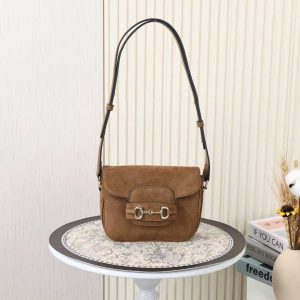Batch 320....2025 Fall/Winter Collection. This shoulder bag reinterprets the brand's equestrian-inspired design, featuring light gold-tone details and suede material, complemented by double rings and elongated hardware, adding another chapter to the Gucci Horsebit 1955 series.Brown suede Gold-tone hardware Brown leather lining Horsebit interior One open pocket Three-compartment design Adjustable shoulder strap Height: 28 cm – 50 cmLength: 71 cm – 114 cm Model: 847064 Dimensions: 19.5 cm (W) x 15 cm (H) x 9 cm (D) Color: Brown suede/natural leather.