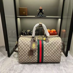 Batch 370...G G Savoy Collection masterfully blends beige and dark brown hues with a classic silhouette, crafted from exceptionally soft fabrics. This travel bag features GG interlocking pattern coated fabric, adorned with the Double G logo and woven strap details.Beige and dark brown GG interlocking pattern coated fabric, dark brown leather piping, gold-tone hardware, green linen-cotton blend lining. Model: 834460. Dimensions: 44 x 29 x 25 cm.