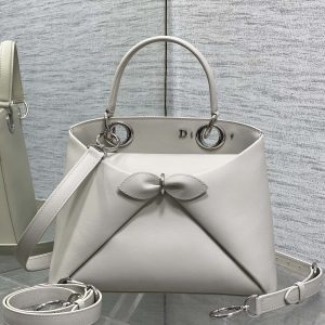 Silver Buckle In Stock‼️ Dior 2026's latest bow-adorned tote bag, featuring a signature bow welded into the design. The bow no longer evokes a sweet, girlish vibe; instead, its newly crafted silhouette and shape, paired with a rich color palette, suit a diverse range of individuals. It strikes the perfect balance between sweet and edgy. Size: 28*10*22