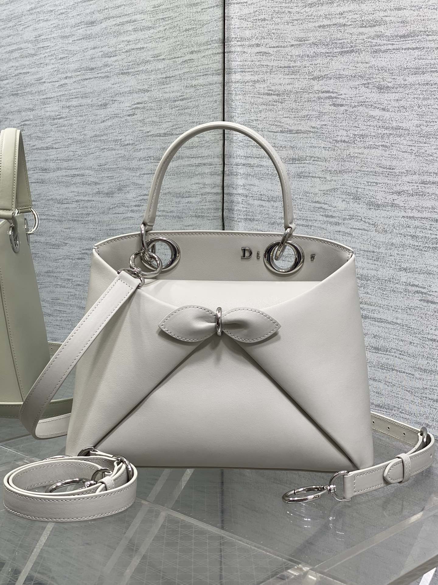 Silver Buckle In Stock‼️ Dior 2026's latest bow-adorned tote bag, featuring a signature bow welded into the design. The bow no longer evokes a sweet, girlish vibe; instead, its newly crafted silhouette and shape, paired with a rich color palette, suit a diverse range of individuals. It strikes the perfect balance between sweet and edgy. Size: 28*10*22