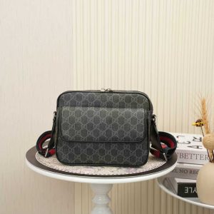 Batch 310... Style No. 795479 Dimensions 23x18x12 cm Gucci crossbody bag, black GG canvas with black leather trim, adjustable red and blue woven strap, cotton-linen lining, one interior zippered pocket, one exterior zippered pocket.