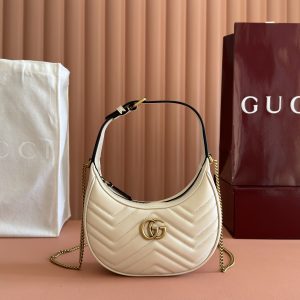 p710. 📣📣📣【Genuine Leather with 🌈 Configuration & Full Boutique Packaging】🔥🔥 This mini handbag features a crescent silhouette and rich black leather, exuding a strong vintage aesthetic.Blending vintage elements with archival designs or contemporary details, it presents a timelessly fresh aesthetic. Every detail reflects the brand's deep fascination with its heritage, and this compact accessory is no exception. Crafted from boutique-quality soft natural full-grain cowhide leather with premium smooth glossy bronze hardware. Model: 699514 Dimensions: 21x11x5cm Color: White