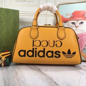 Batch 390...🔥🔥 adidas x Gucci Collaboration Mini Travel Bag. As part of the adidas x Gucci collaboration collection, this mini travel bag features "Gucci adidas" and Trefoil prints. adidas and Gucci boldly explore this collaborative series, where woven straps and GG lettering patterns artfully complement the white three-stripes and Trefoil logo.Drawing inspiration from the creative director's nostalgic memories of the 80s and 90s, the collection merges the rich heritage and iconic design language of both brands to shape distinctive styles. The "Gucci adidas" and Trefoil print white leather trim adidas x Gucci collaboration features red and green woven straps, interlocking double Gs, and a Trefoil print cotton-linen lining. Model: 702397.Dimensions: 31.5*18*15.5cm. Color: White leather/adidas collaboration edition.