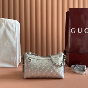 p710. [Complete with original boutique packaging] The GG Emblem collection reimagines the brand's enduring elegance and craftsmanship, featuring a metallic-effect design that reinterprets the iconic GG pattern. Paired with matching leather piping, the overall design achieves perfect harmony.Silver metallic GG patent leather Silver metallic leather trim Silver-tone hardware Brown cotton-linen blend lining Interior: Open pocket Chain shoulder strap (23 cm drop) Leather shoulder strap: Height: 48 cm – 54 cm; Length: 99 cm – 109 cm Zipper closure Model: 851631.Dimensions: 22 cm (width) x 14 cm (height) x 8 cm (depth) Weight: Approx. 0.45 kg Color: Silver/Embossed Made in Italy