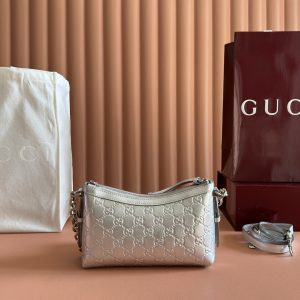 Alternative view of p710. [Complete with original boutique packaging] The GG Emblem collection reimagines the brand's enduring elegance and craftsmanship, featuring a metallic-effect design that reinterprets the iconic GG pattern. Paired with matching leather piping, the overall design achieves perfect harmony.Silver metallic GG patent leather Silver metallic leather trim Silver-tone hardware Brown cotton-linen blend lining Interior: Open pocket Chain shoulder strap (23 cm drop) Leather shoulder strap: Height: 48 cm – 54 cm; Length: 99 cm – 109 cm Zipper closure Model: 851631.Dimensions: 22 cm (width) x 14 cm (height) x 8 cm (depth) Weight: Approx. 0.45 kg Color: Silver/Embossed Made in Italy