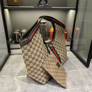 Alternative view of Lot 320...GG Giglio Oversized Tote, newly unveiled at the Florence 2026 Pre-Spring Fashion Show, pays homage to the brand's Italian heritage, blending timeless tradition with innovative spirit. This spacious tote is expertly crafted from GG canvas, adorned with woven ribbon piping, and includes a detachable clutch.Product Details · Off-white and dark brown GG canvas · Red and green woven ribbon piping · Green cotton lining · Double G logo · Includes detachable clutch · Magnetic snap closure Model: 853971 Dimensions: 60x47x16cm