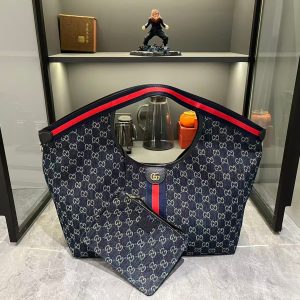 Lot 320...GG Giglio Oversized Tote, newly unveiled at the Florence 2026 Pre-Spring Fashion Show, pays homage to the brand's Italian heritage, blending timeless tradition with innovative spirit. This spacious tote is expertly crafted from GG canvas, adorned with woven ribbon piping, and includes a detachable clutch.Product Details · Off-white and dark brown GG canvas · Red and green woven ribbon piping · Green cotton lining · Double G logo · Includes detachable clutch · Magnetic snap closure Model: 853971 Dimensions: 60x47x16cm