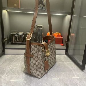 Alternative view of Batch 320... The GG Padlock collection introduces a range of stylish bags with versatile carrying options, enhancing the 2025 Pre-Fall lineup. This shoulder bag features a central compartment with a zippered pocket and a webbing lining reminiscent of the brand's iconic pattern.Beige and dark brown GG monogram coated fabric with brown leather trim, light gold-tone hardware, red and green woven cotton lining, padlock-style closure with leather keyring. Model: 839021. Dimensions: 29x 23.5x 15.5