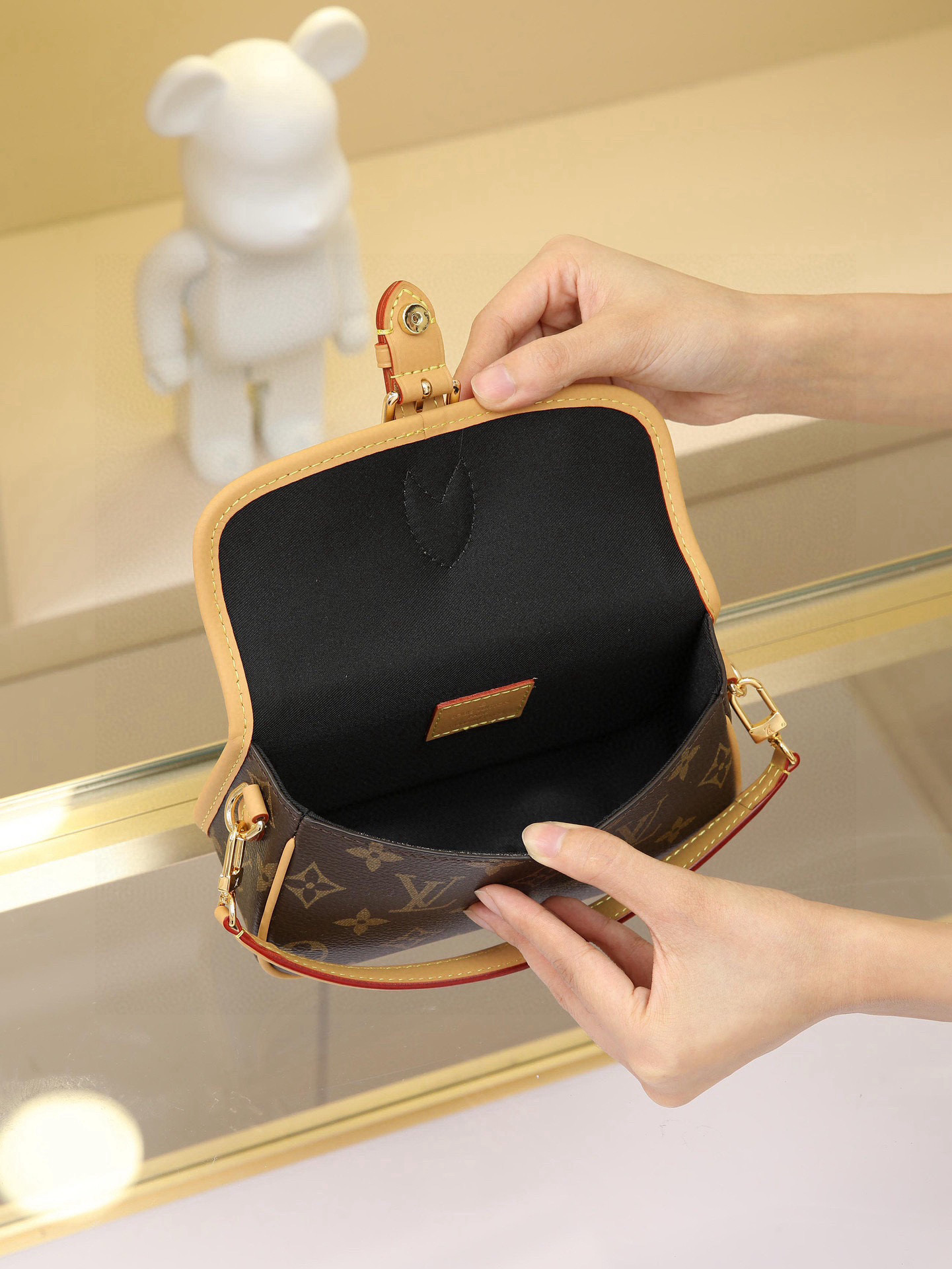 This Diane mini handbag features a Monogram canvas body with vintage elements like leather corners and a traditional clasp. A miniature version of the Diana model, it offers ample space for your phone and other essentials. It showcases the most distinctive details of the original design, such as the circular flap and belt closure. This versatile piece, perfect for day or night, features adjustable wings and a waist strap, both of which are removable.19 x 10.5 x 6 cm (L x H x W) - Image 8