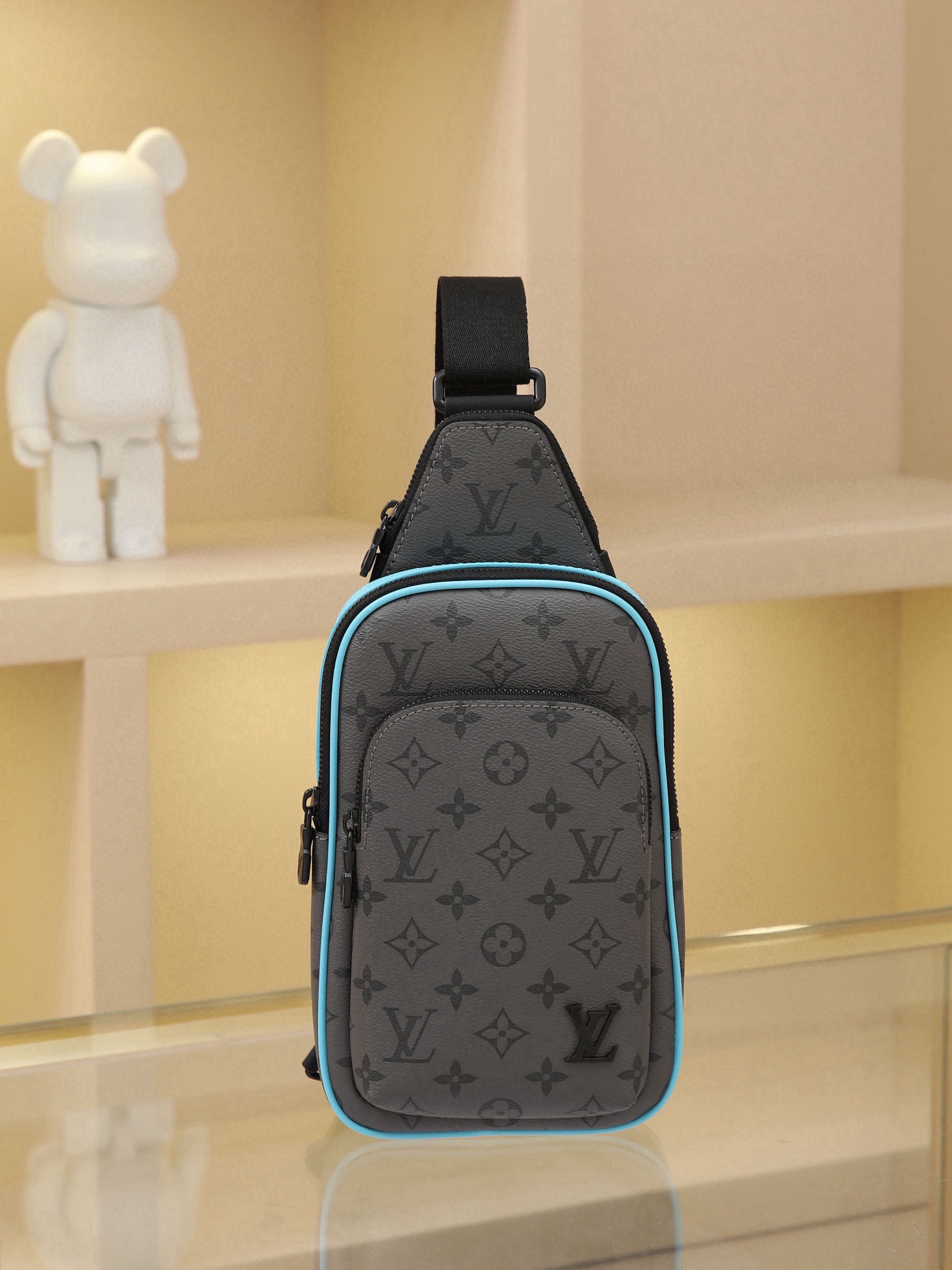 This Avenue mini shoulder bag features Monogram Eclipse coated canvas, exploring the trend of crossbody styling through its refined silhouette. The main compartment's interior pocket ensures secure storage, while the zippered exterior pocket offers easy access to everyday essentials. A triangular zippered pocket is positioned where the shoulder strap meets the bag. Dimensions: 16 × 33 × 5.7 cm