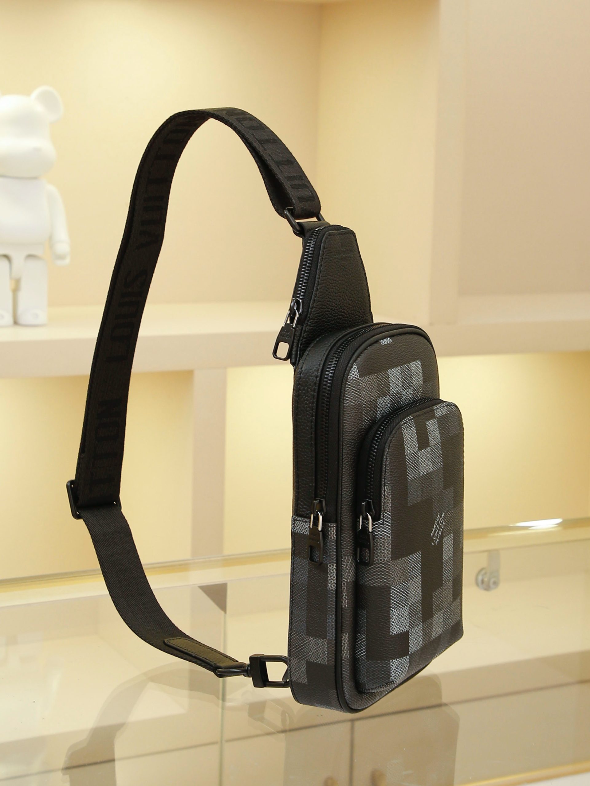 AVENUE Shoulder Bag crafted from Pharrell Williams' reimagined Damoflage Black coated canvas, blending the designer's avant-garde vision with the brand's heritage creativity. Features a pixelated camouflage-inspired Damier pattern and an "intelligent" shoulder strap designed for comfortable wear on either the left or right shoulder. Dimensions: 20x31x10cm - Image 2