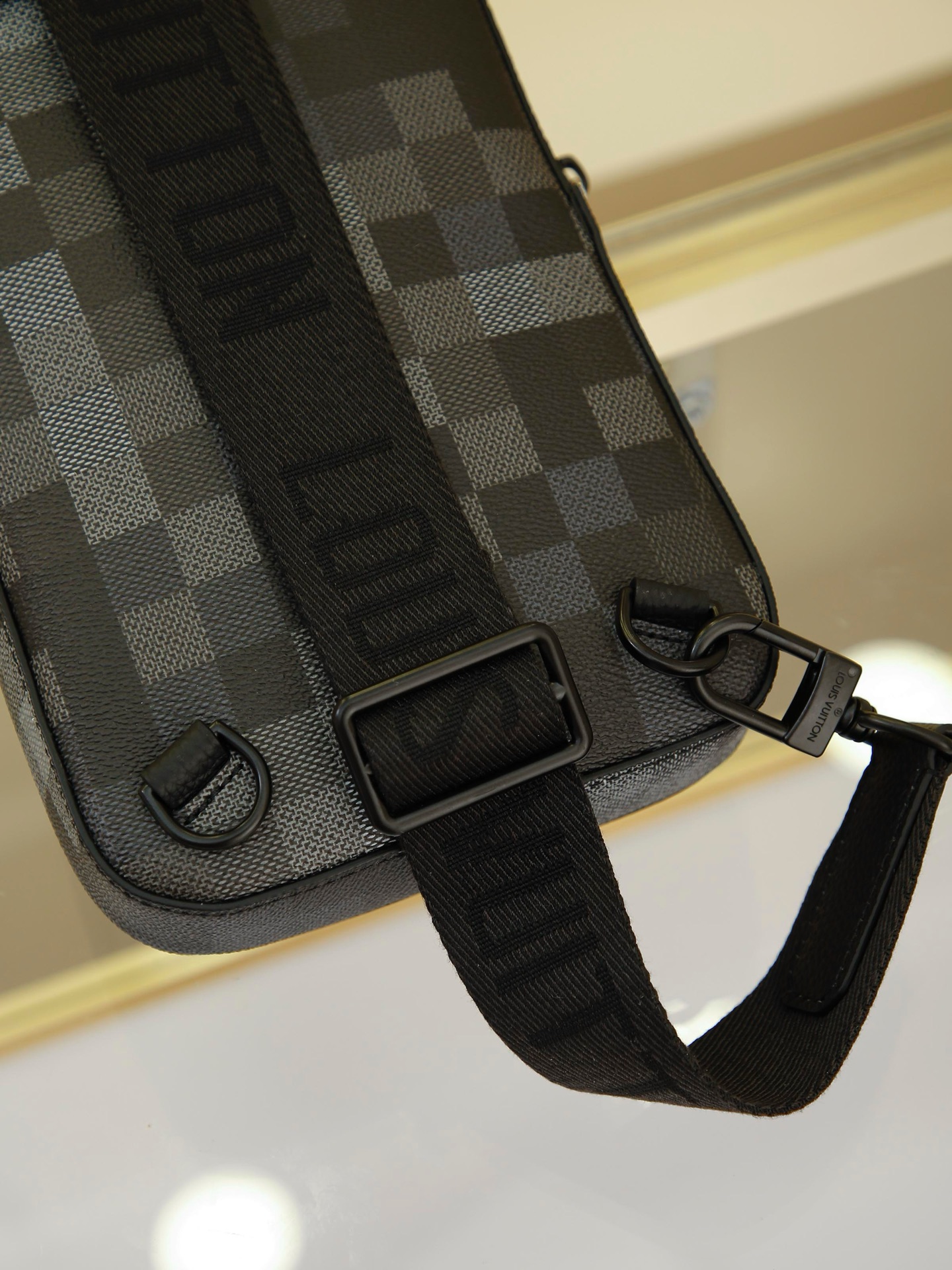 AVENUE Shoulder Bag crafted from Pharrell Williams' reimagined Damoflage Black coated canvas, blending the designer's avant-garde vision with the brand's heritage creativity. Features a pixelated camouflage-inspired Damier pattern and an "intelligent" shoulder strap designed for comfortable wear on either the left or right shoulder. Dimensions: 20x31x10cm - Image 7