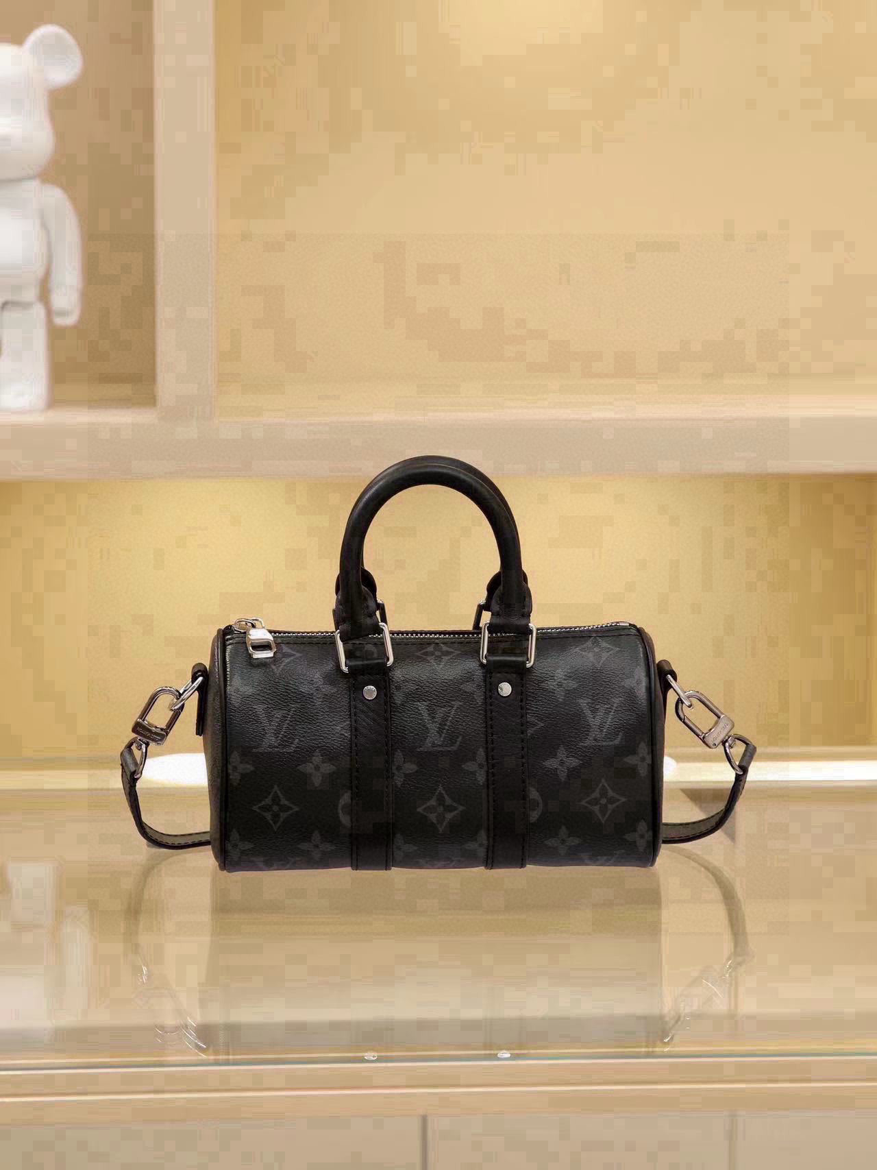 All-Steel Hardware Speedy Pillow Bag Collection This Keepall XS handbag is now available. Perfect for women, yet unisex in design. The black monogram pattern exudes sophistication. Most importantly, the shoulder strap is adjustable. Features: Monogram coated canvas, leather trims, fabric lining, zipper closure, removable and adjustable shoulder strap. Dimensions: 21 × 12 × 9 cm